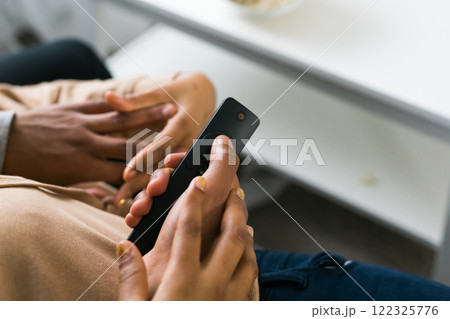 Remote control is pointed toward the television screen, control and choice of tv entertainment. TV, series and streaming service concept Remote control is pointed toward the television screen, control and choice of tv entertainment. TV, series and streaming service concept 122325776