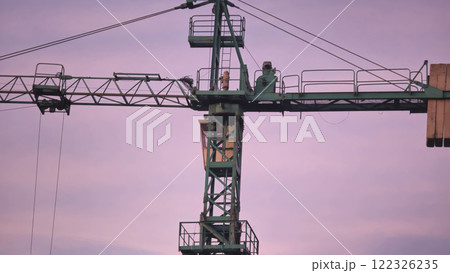 Construction crane with a long boom against the background of a light sky. Construction crane with a long boom against the background of a light sky. 122326235
