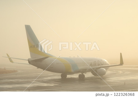 霧の中、朝日を浴びる飛行機 122326368