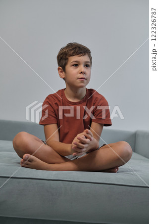 With a mischievous smile, he sits relaxed, highlighting the importance of downtime in children's increasingly busy lives. With a mischievous smile, he sits relaxed, highlighting the importance of downtime in children's increasingly busy lives. 122326787