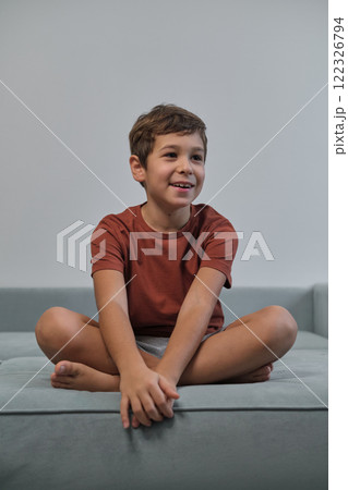 Seated with a cheeky grin, he captures the essence of playful youth, countering the narrative of over-scheduled children. 122326794