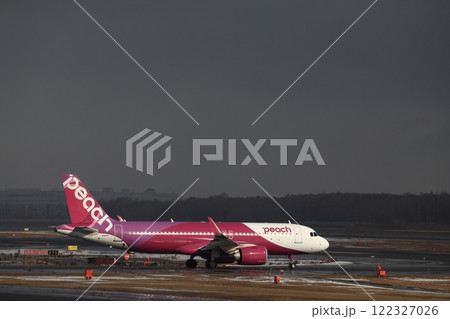 暗い空に光を浴びる飛行機 122327026