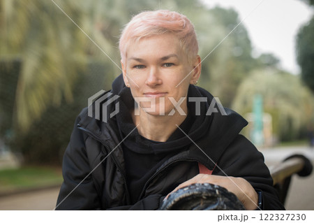 Attractive mature woman sitting on a park bench 122327230