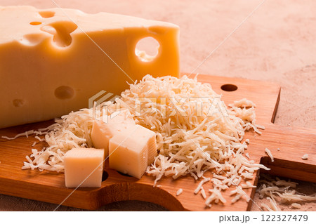 Grated cheese, Maasdam, on a cutting board, grater and cheese knife, close-up, no people, 122327479