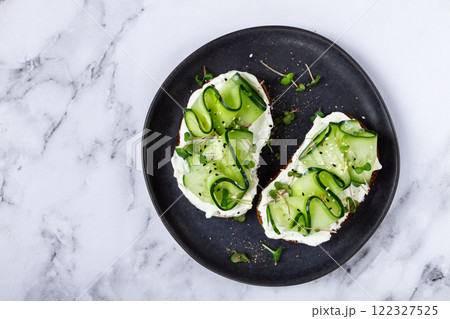Breakfast, grain bread sandwiches, cream cheese, sliced cucumber, with microgreens, and sesame seeds, on a light table, close-up, top view, selective focus, no people, Breakfast, grain bread sandwiches, cream cheese, sliced cucumber, with microgreens, and sesame seeds, on a light table, close-up, top view, selective focus, no people, 122327525