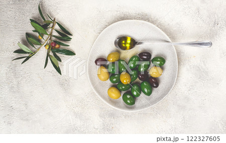 a mix of olives, a variety of Chalkidiki, verdi giganti and Kalamata, on a plate with a spoonful of olive oil, top view, no people, 122327605