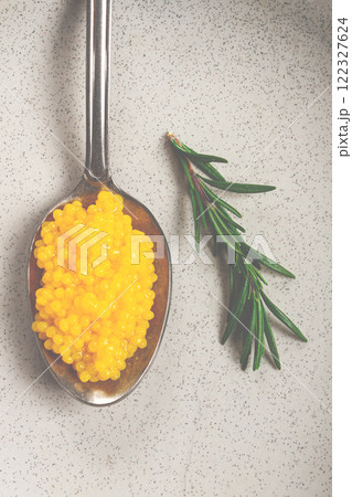 Yuzu caviar is pearly, on a spoon, top view, light background, no people. 122327624