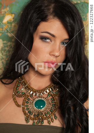 Glamorous brunette woman posing in art studio. Young lady with long curly hair and make-up  122327668