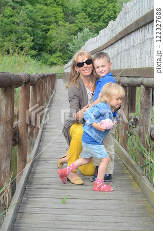Grandmother with little grandchildren on a wooden path 122327688