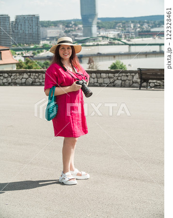 Smiling woman using a camera to take photo outdoors at the park 122328461