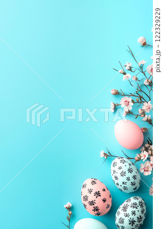 Easter blue background with Easter eggs creatively painted with patterns of black flowers and decorated with branches of blossoming spring trees. Banner with copy space, for text 122329229
