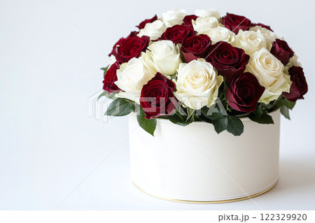 Bouquet of red and white roses in a round elegant gift box on white background, 122329920