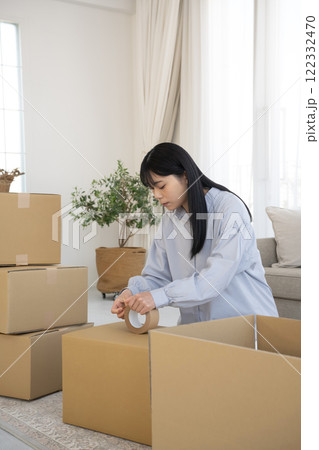 段ボールにガムテープを張る女性 122332470