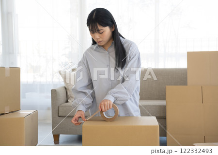 段ボールにガムテープを張る女性 122332493