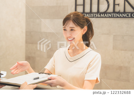 笑顔で受付をする医院の女性イメージ 122332688