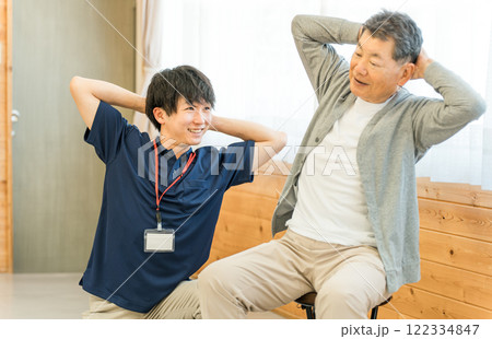 リハビリで体操をするシニア男性と理学療法士・作業療法士の男性スタッフ リハビリで体操をするシニア男性と理学療法士・作業療法士の男性スタッフ 122334847