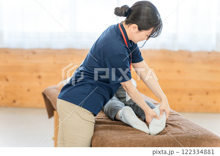 シニア女性をマッサージするあん摩マッサージ指圧師・理学療法士の女性 122334881