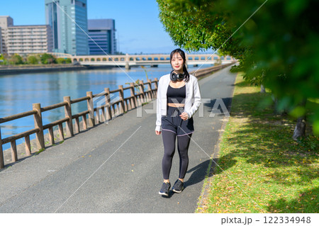 川沿いの歩道をウォーキングするかっこいい女性 ダイエット 散歩 運動 川沿いの歩道をウォーキングするかっこいい女性 ダイエット 散歩 運動 122334948