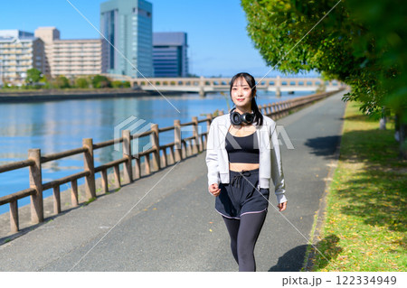 川沿いの歩道をウォーキングするかっこいい女性 ダイエット 散歩 運動 川沿いの歩道をウォーキングするかっこいい女性 ダイエット 散歩 運動 122334949
