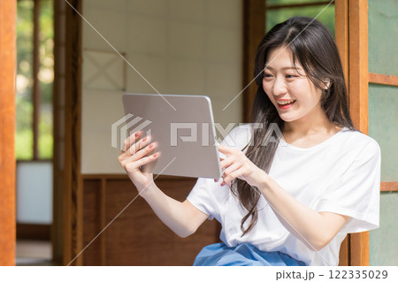 タブレット見てタッチ操作している若い女性 タブレット見てタッチ操作している若い女性 122335029