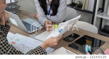 Business team analyzing data charts and discussing strategies in a modern office Business team analyzing data charts and discussing strategies in a modern office 122335110
