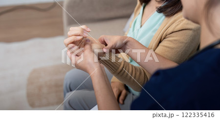 Caregiver examining elderly patient for symptoms of disease during a compassionate check up Caregiver examining elderly patient for symptoms of disease during a compassionate check up 122335416