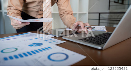 Businessman reviewing analytics and financial projections on a tablet, enhancing decision-making in a modern office 122335421