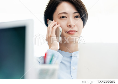 オフィスで通話するビジネスウーマン オフィスで通話するビジネスウーマン 122335503