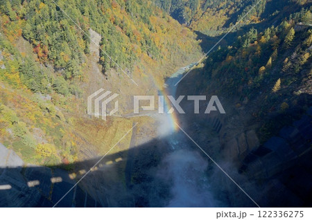富山県の黒部ダムの堤体からのぞきこむ虹と紅葉 122336275