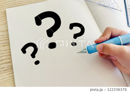 勉強のノートにはてなマークを描く人の手 122336378