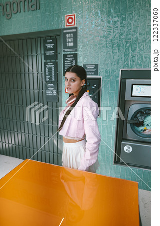 Chic Urban Vibes A Stylish Woman Exudes Elegance in a Modern, Trendy Laundromat Setting 122337060