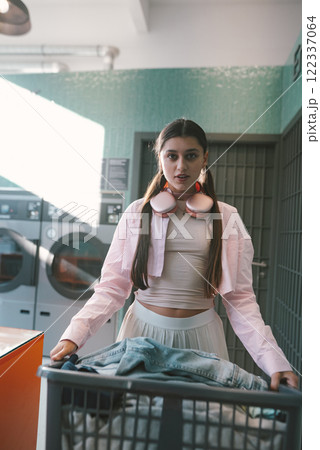 A Young Woman Engaged in Laundry Activities While Wearing Stylish Athletic Apparel 122337064