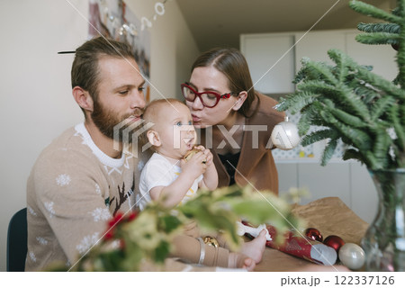 A family joyfully celebrates Christmas with their toddler at home, creating lasting memories 122337126