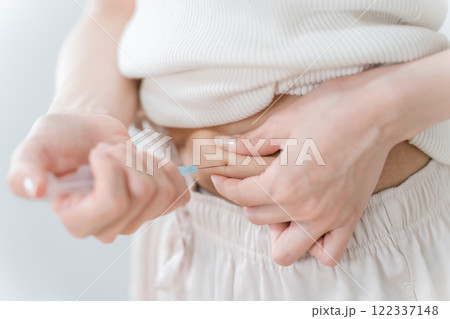 お腹をつまんでインスリン注射・ダイエット注射・不妊治療薬を注射する女性 お腹をつまんでインスリン注射・ダイエット注射・不妊治療薬を注射する女性 122337148