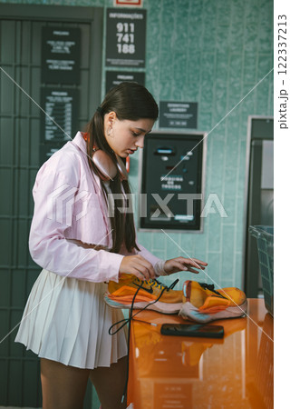 A Young Woman Engaged Deeply in Music at a Vibrant Urban Venue During a Lively Event A Young Woman Engaged Deeply in Music at a Vibrant Urban Venue During a Lively Event 122337213
