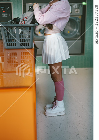 A Trendy Young Woman at the Laundromat, Dressed in a Very Stylish and Fashionable Attire 122337329