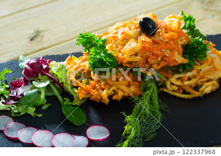 Vegetarian dish, carrots cutlets with greens served at black plate 122337968