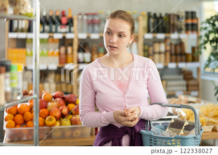 Young girl choosing food in grocery store 122338027