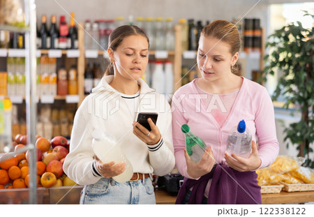 Two customers scanning the barcode of soda bottles 122338122