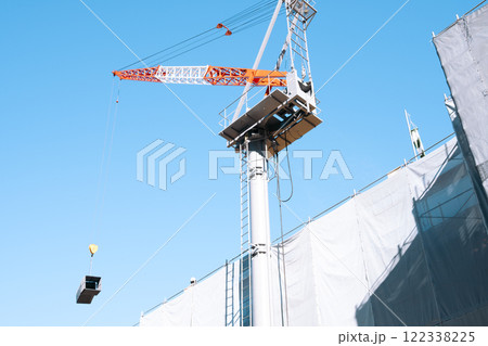 ビル建築現場 快晴の空と資材を吊り上げるタワークレーン ライトトーン ビル建築現場 快晴の空と資材を吊り上げるタワークレーン ライトトーン 122338225