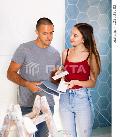 Positive married couple choosing ceramic bathroom border together 122338382