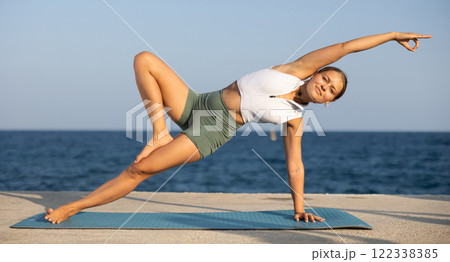 Various yoga poses performed by a sporty girl on sunny seaside Various yoga poses performed by a sporty girl on sunny seaside 122338385