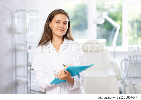 Young female doctor taking notes in medical room 122338457