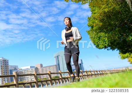 川沿いの歩道をウォーキングするかっこいい女性　歩く　ダイエット　散歩　運動　 122338535