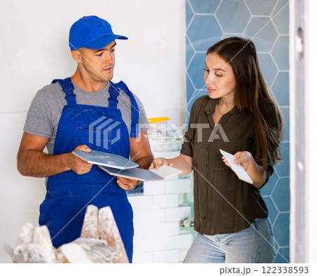 Worker talking with woman about bathroom tile Worker talking with woman about bathroom tile 122338593
