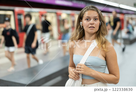 Young girl standing in platform with wireless headphones on airs Young girl standing in platform with wireless headphones on airs 122338630