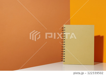 The notebook stands on a yellow background The notebook stands on a yellow background 122339502