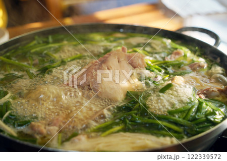Korean food made by boiling whole chicken with garlic and seasoning it with salt 122339572