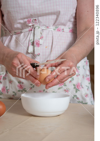 women's hands break a chicken egg 122340896