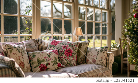 Colorful pillows on sofa against glass wall of window in a winter garden or conservatory. Interior textile concept. High quality photo 122341521
